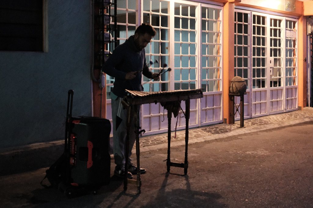 Músico callejero iluminado con un faro de luz cálida