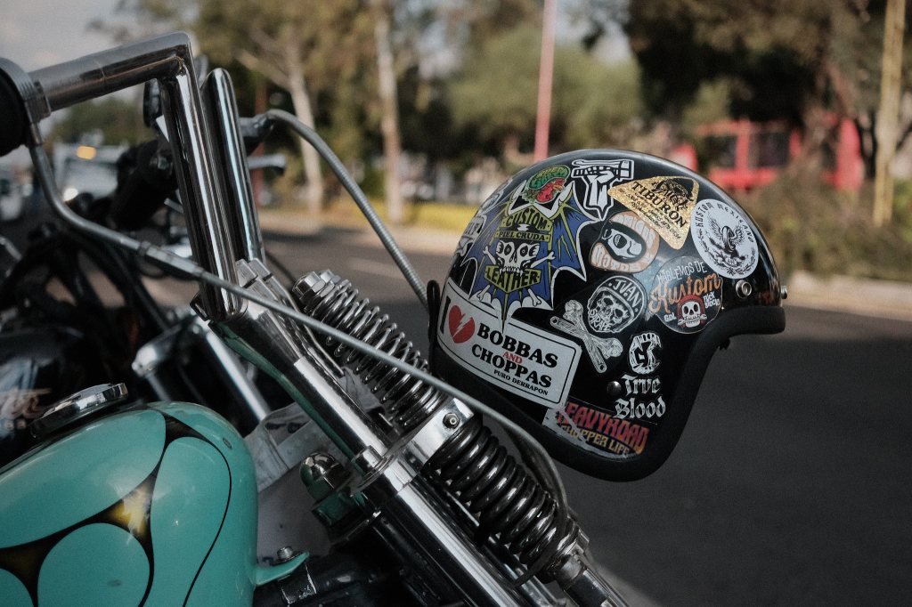 Casco de motociclista con stickers sobre una suspensión springer de una Harley Davidson Sportster
