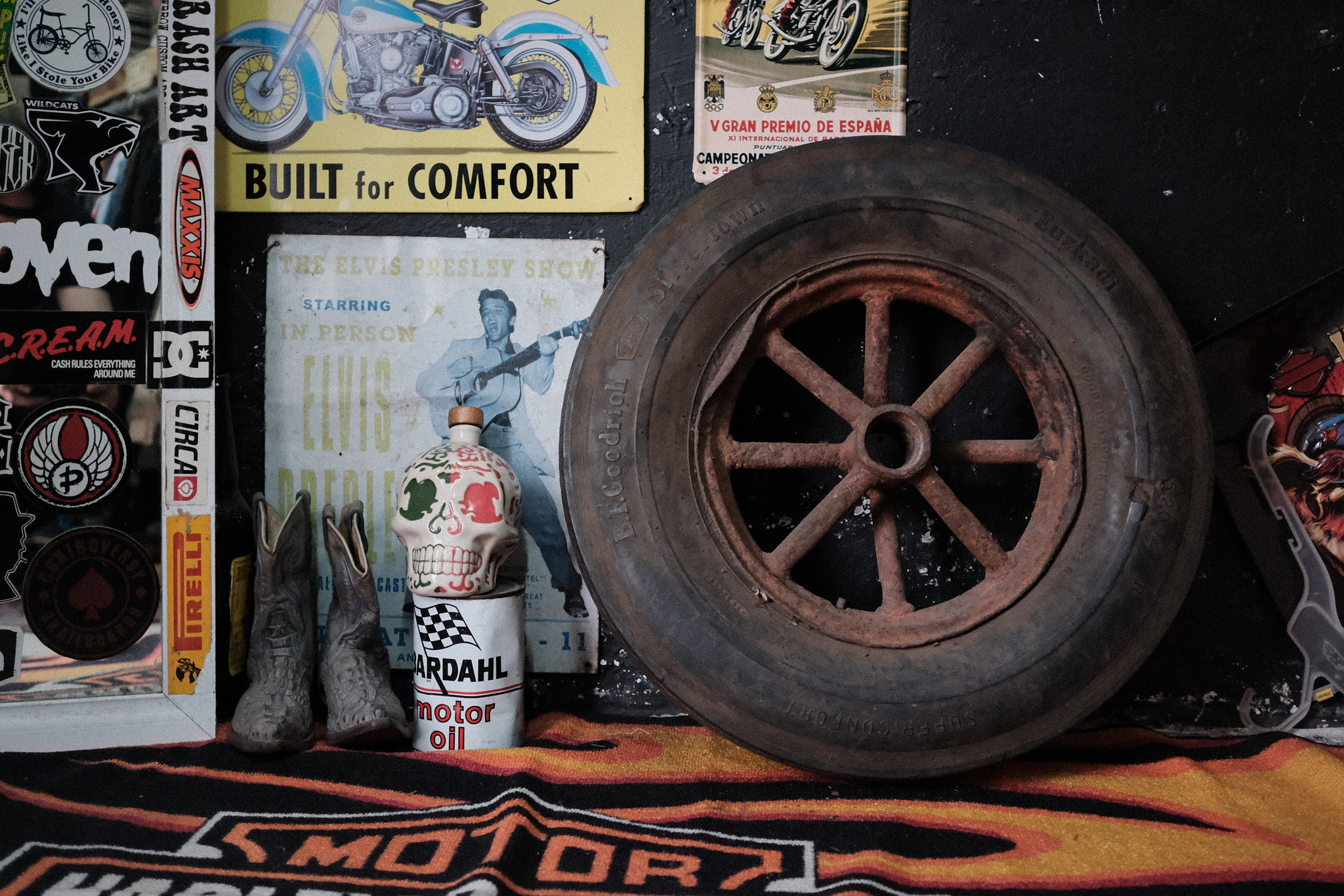 Llanta con rin oxidado junto a una botella metálica de aceite