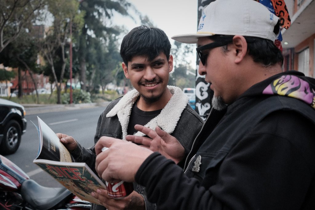 Hombres viendo una revista de motociclismo y skate