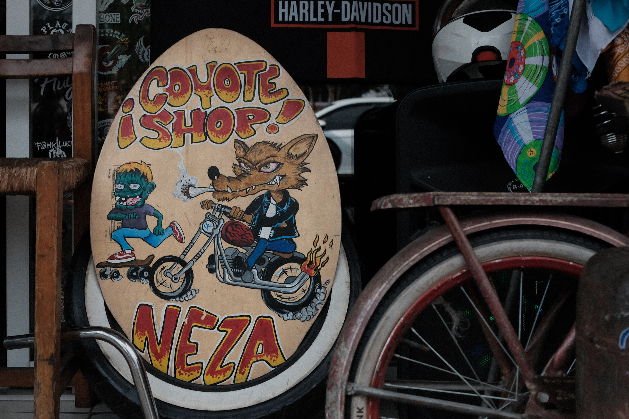 Bicicleta oxidada junto a una pintura de un coyote en motocicleta