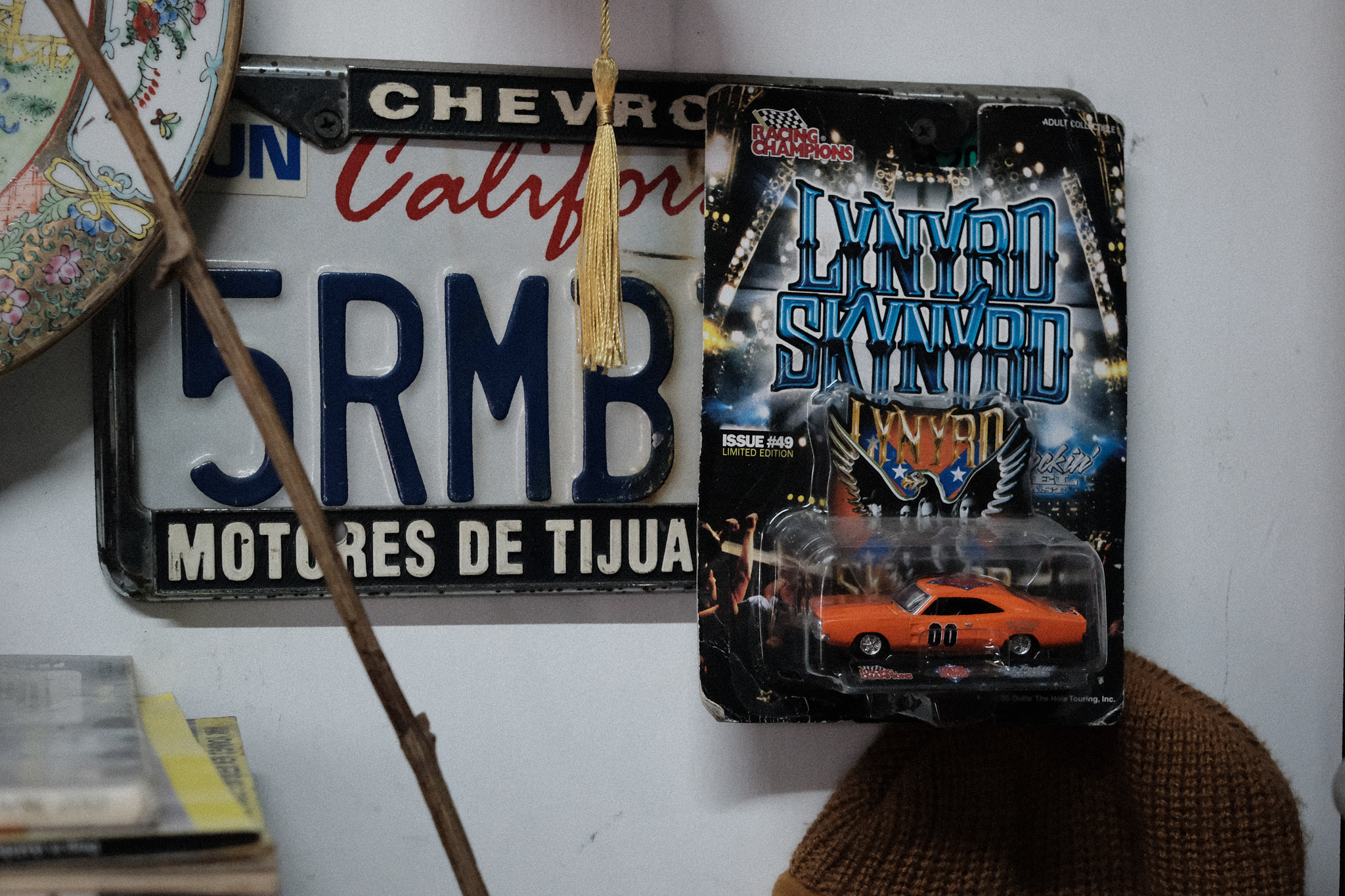 Auto de juguete anaranjado edición Lynyrd Skynyrd sobre una placa de auto vieja