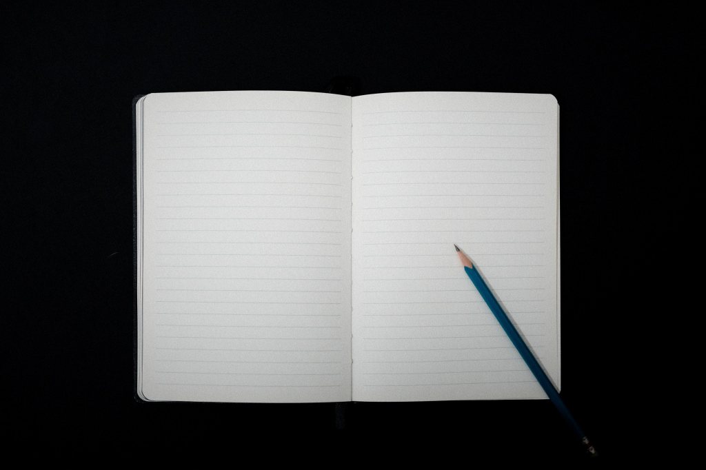 Cuaderno abierto en blanco sobre un escritorio, símbolo del proceso de volver a escribir y reflexionar