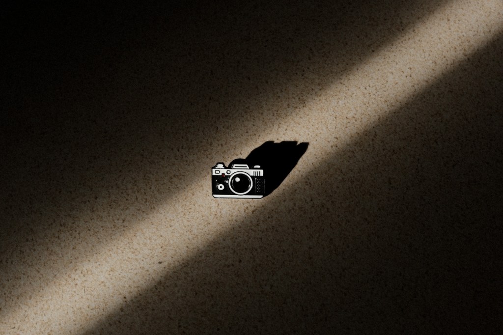 Pin de cámara desde una vista cenital en un haz de luz rodeado de sombras